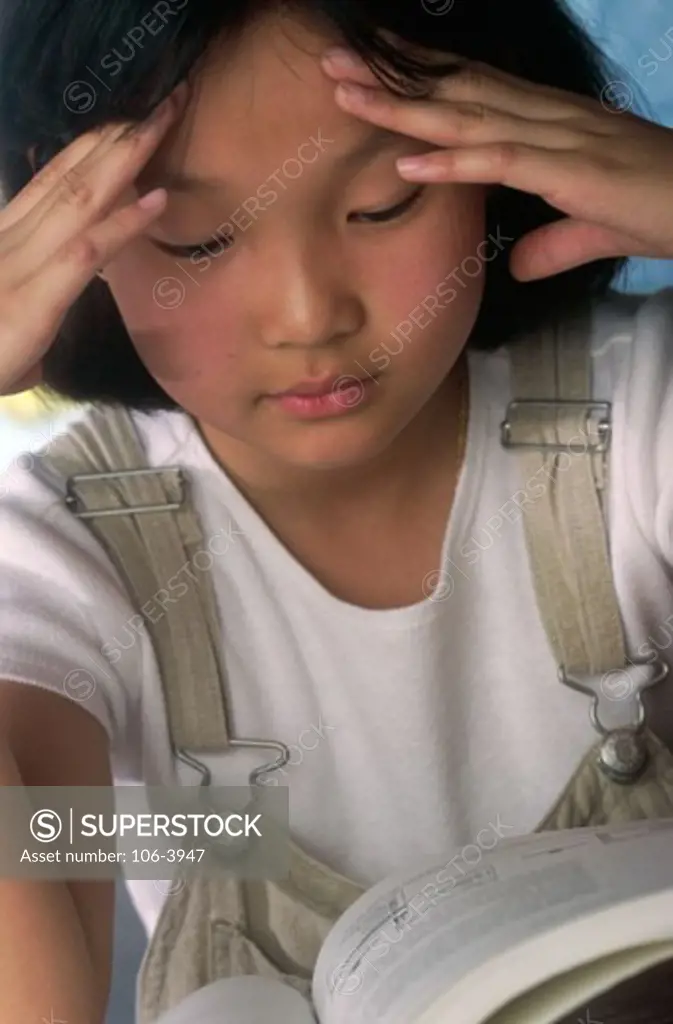 Close-up of a young girl reading a book