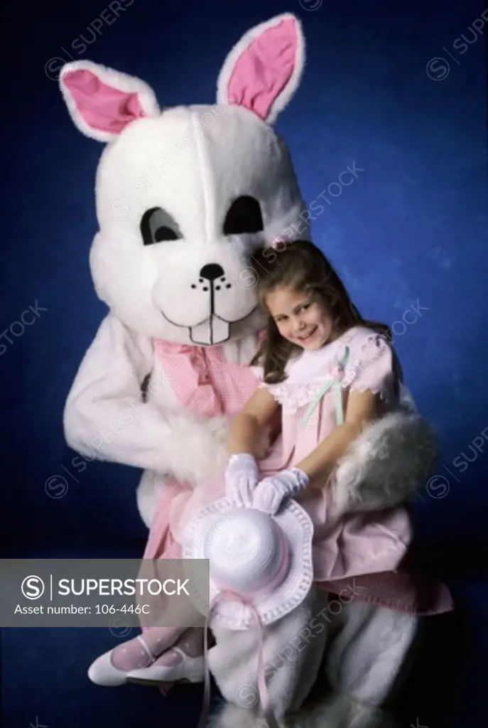 Portrait of a girl sitting on the lap of a person in a rabbit costume