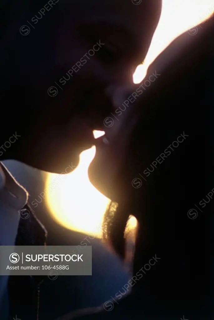 Side profile of a young couple kissing