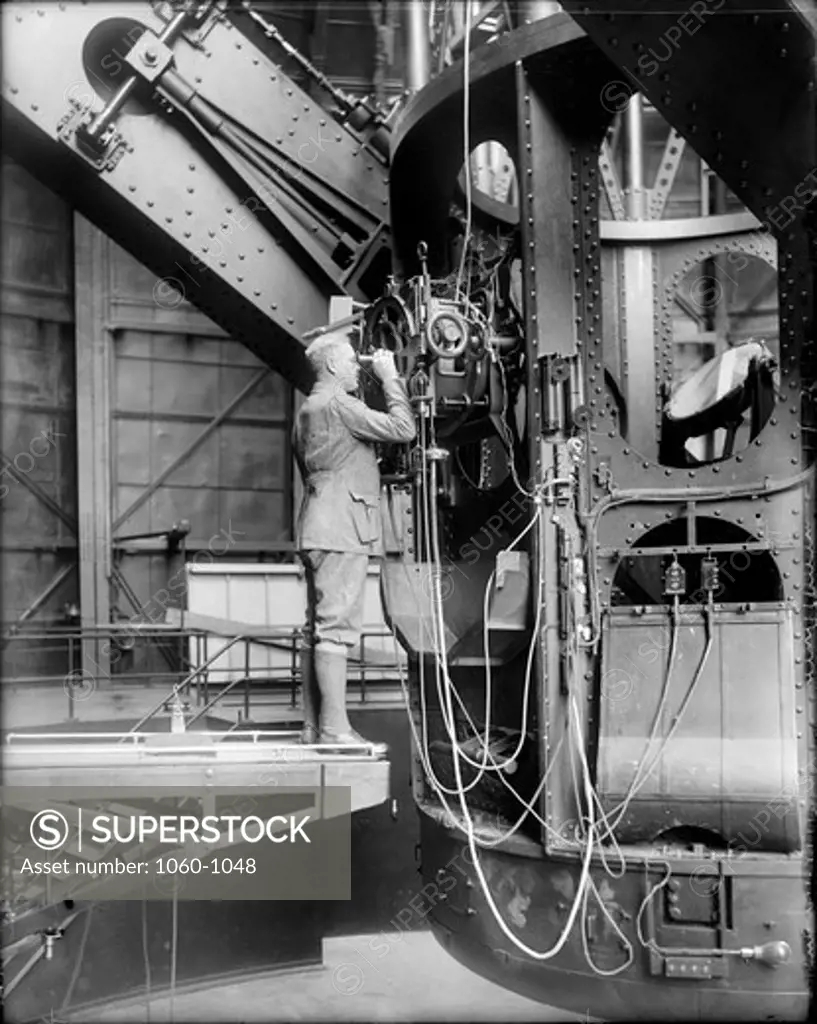 FRANCIS PEASE AT THE CASSEGRAIN FOCUS OF THE 100-INCH TELESCOPE; TUBE IS VERTICAL.