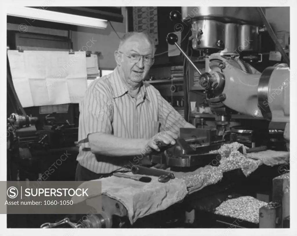 FRED O'NEIL AT A DRILL PRESS IN THE MACHINE SHOP.