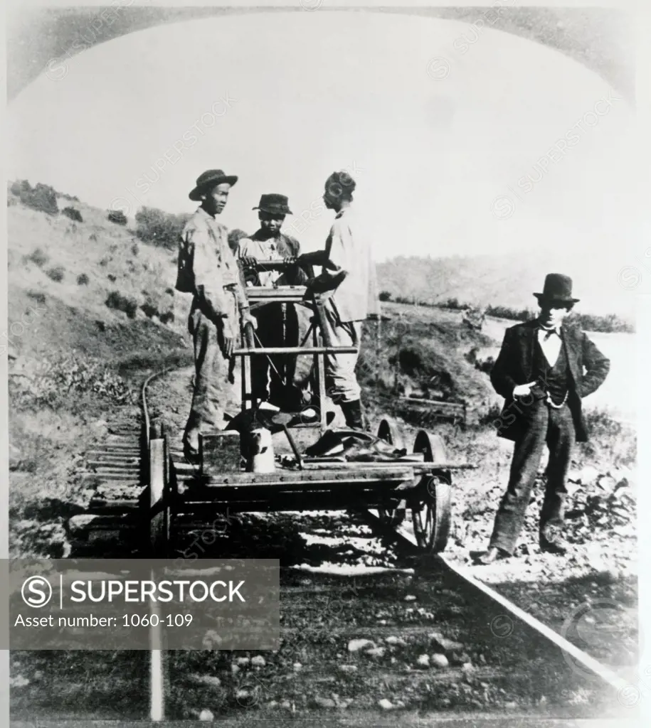 Surveyor looking at railway workers standing on a handcar