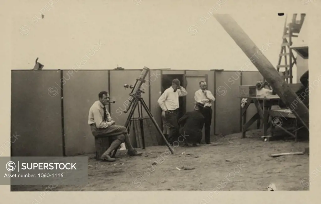 Edwin P. Hubble seated at small telescope at solar eclipse expedition site at Pt. Loma