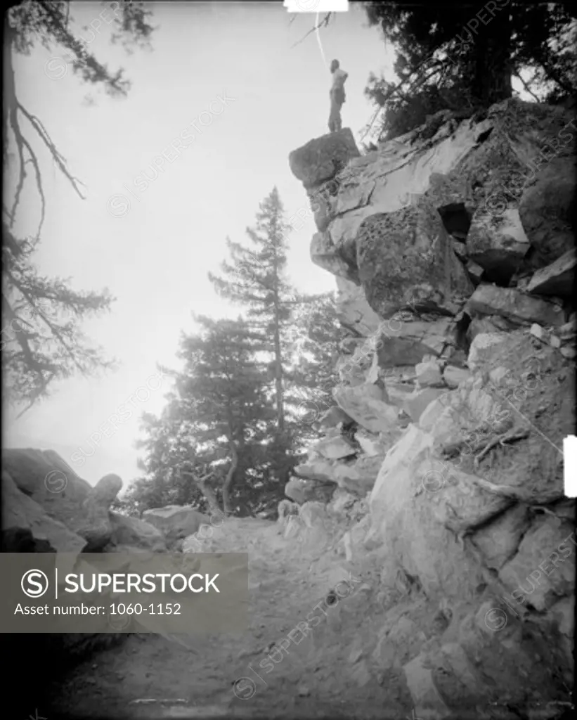 STEEP BANK OF ROCKS AT TURN OF MT. WILSON TOLL ROAD ON NORTHEAST SLOPE OF MT. HARVARD; FERDINAND ELLERMAN STANDING ON TOP OF THE ROCKS.