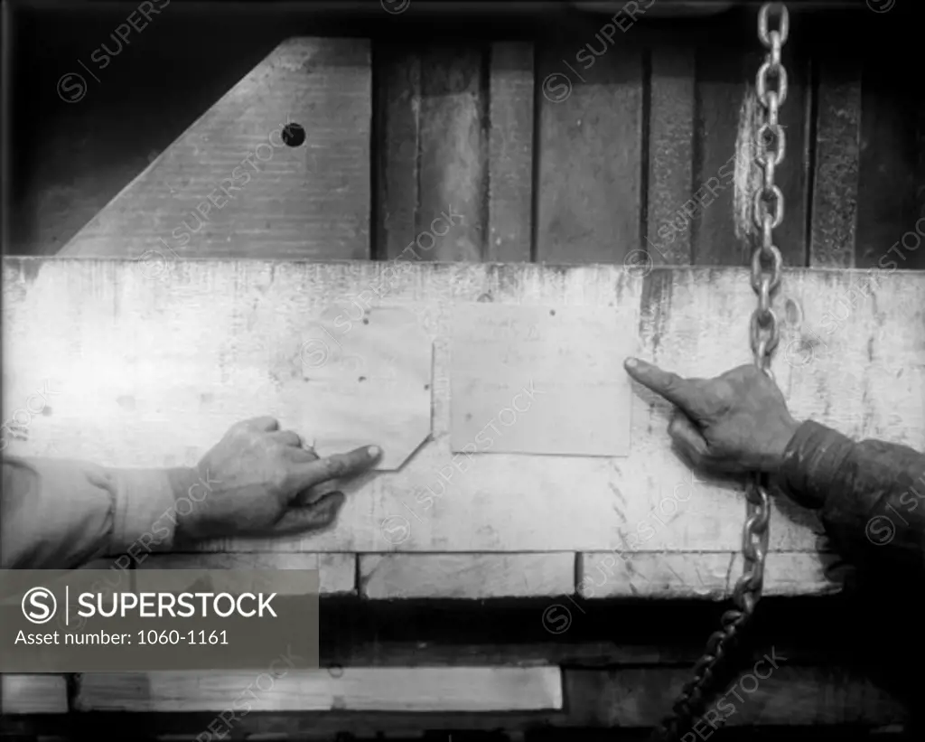 HANDS POINTING TO FIGURES OF WEIGHTS ON LARGE BOX ON 3-TON AUTO TRUCK (GEORGE JONES' HAND AT LEFT).