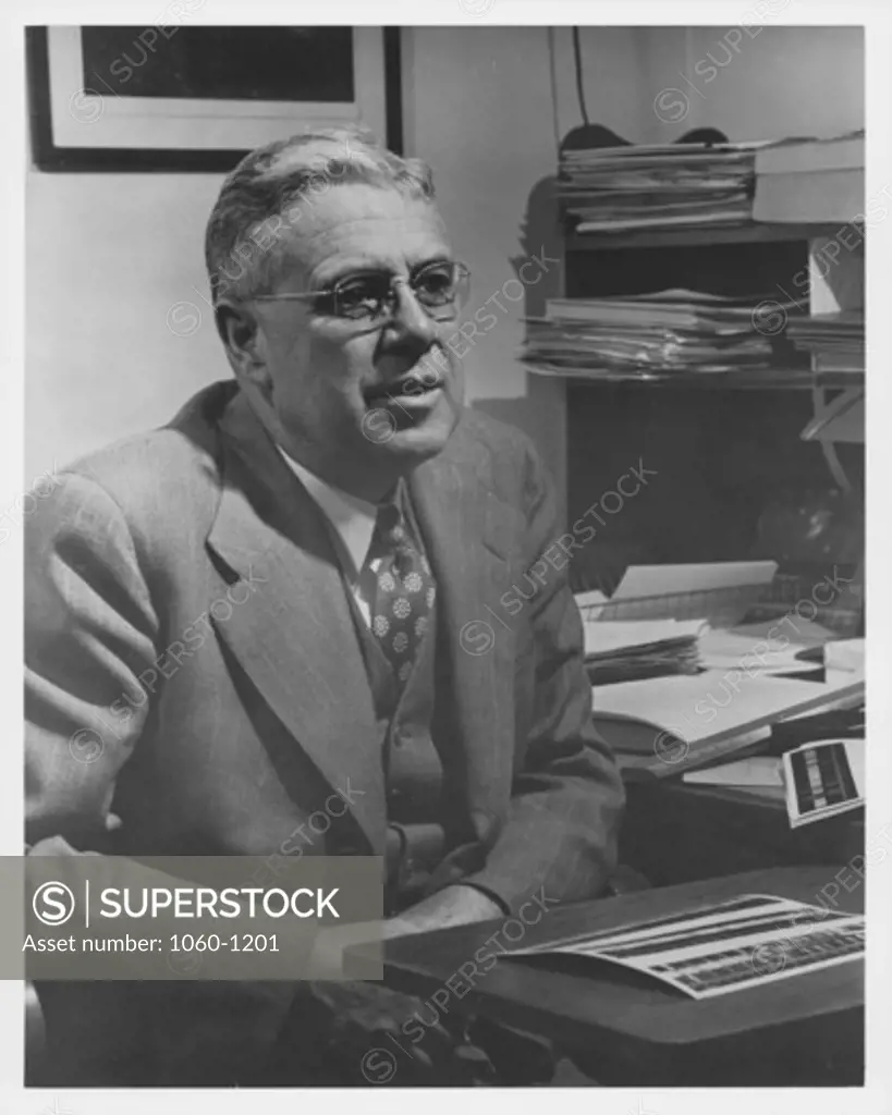 MILTON HUMASON AT HIS DESK.