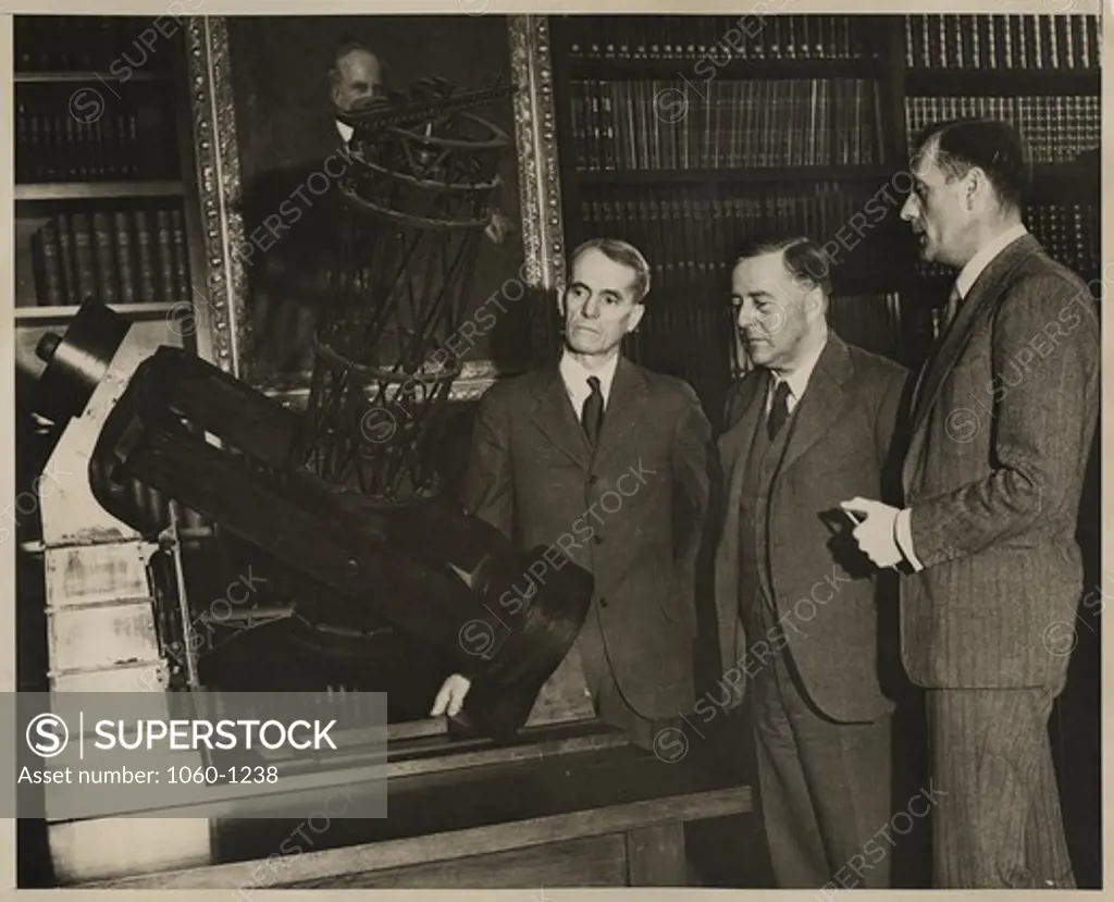 (L to R): Walter S. Adams, James H. Jeans, & Edwin P. Hubble at a model of the 100"" telescope in the Hale Library of the Mt. Wilson Observatory's Main Office Building