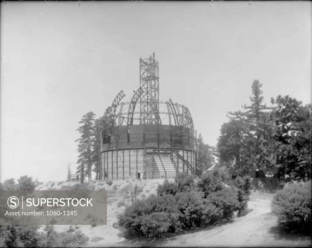 100-INCH TELESCOPE DOME BEING ERECTED WITH CRANE BASE EXTENDING FROM INSIDE THE BUILDING TO WELL ABOVE THE TOP OF THE DOME.