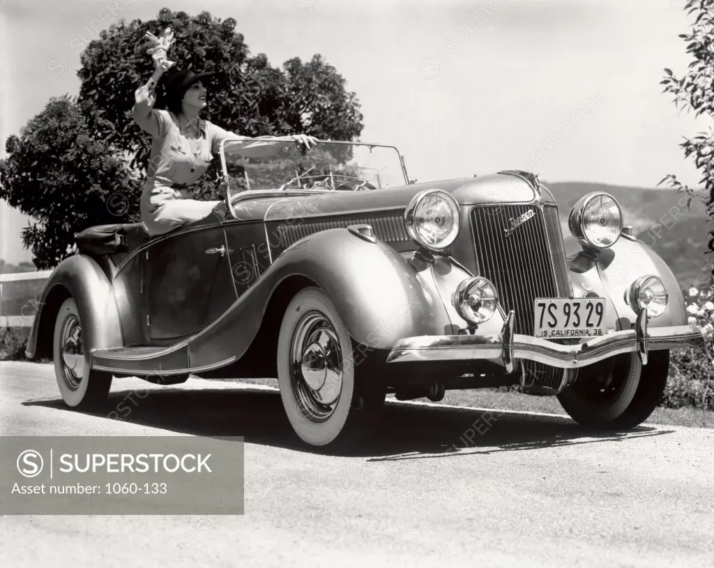 Young woman sitting in a Jensen body convertible car, 1936