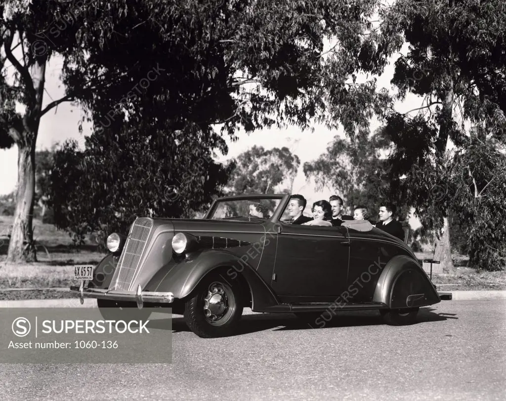 Three teenage couples sitting in a Nash convertible car, 1936