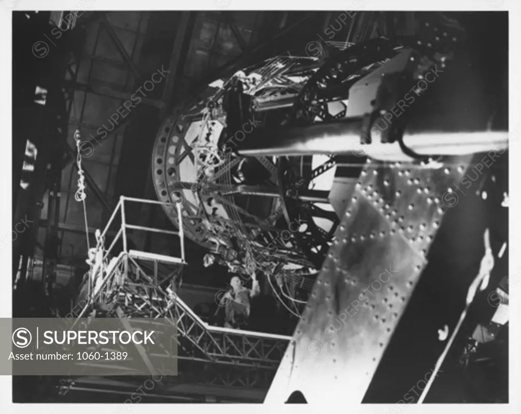 Edwin P. Hubble seated on the Newtonian platform of the 100 inch telescop as viewed from the dome floor