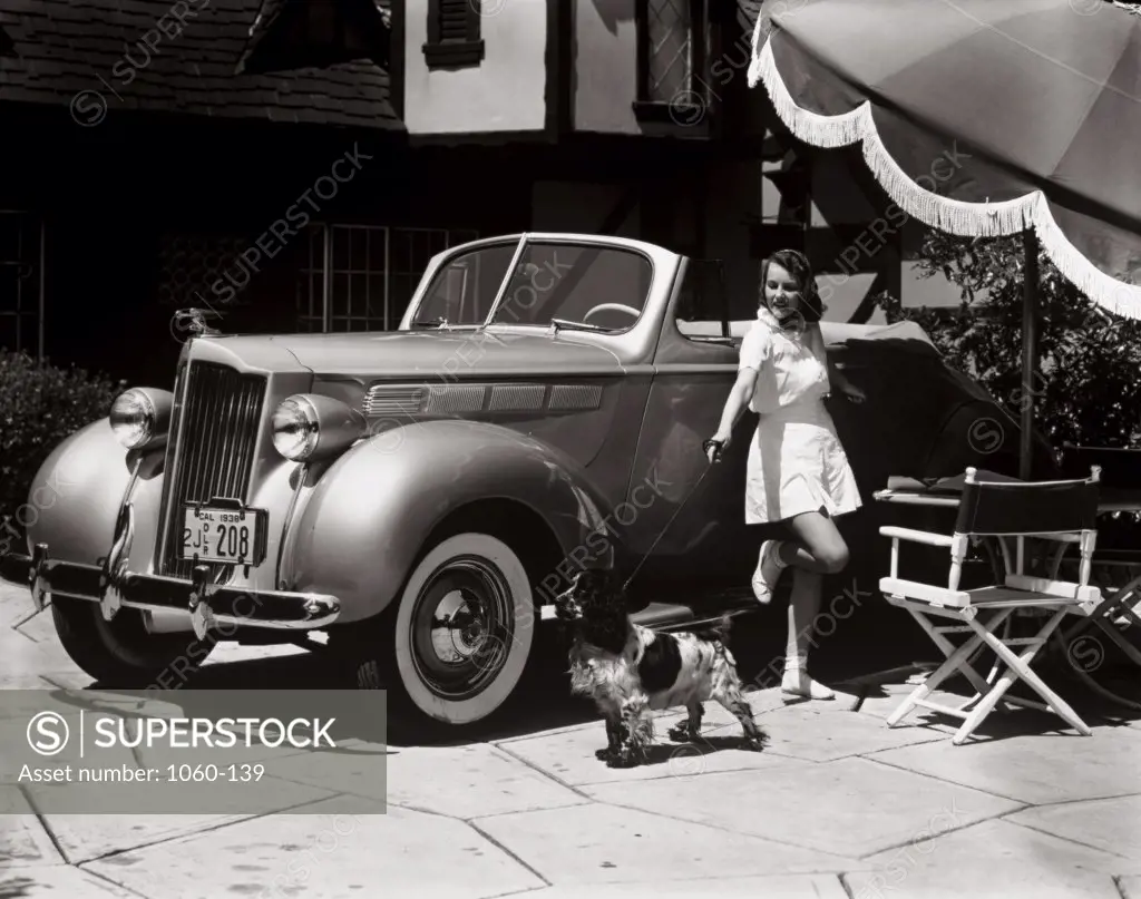 Young woman leaning against a Packard 6 convertible car, 1938