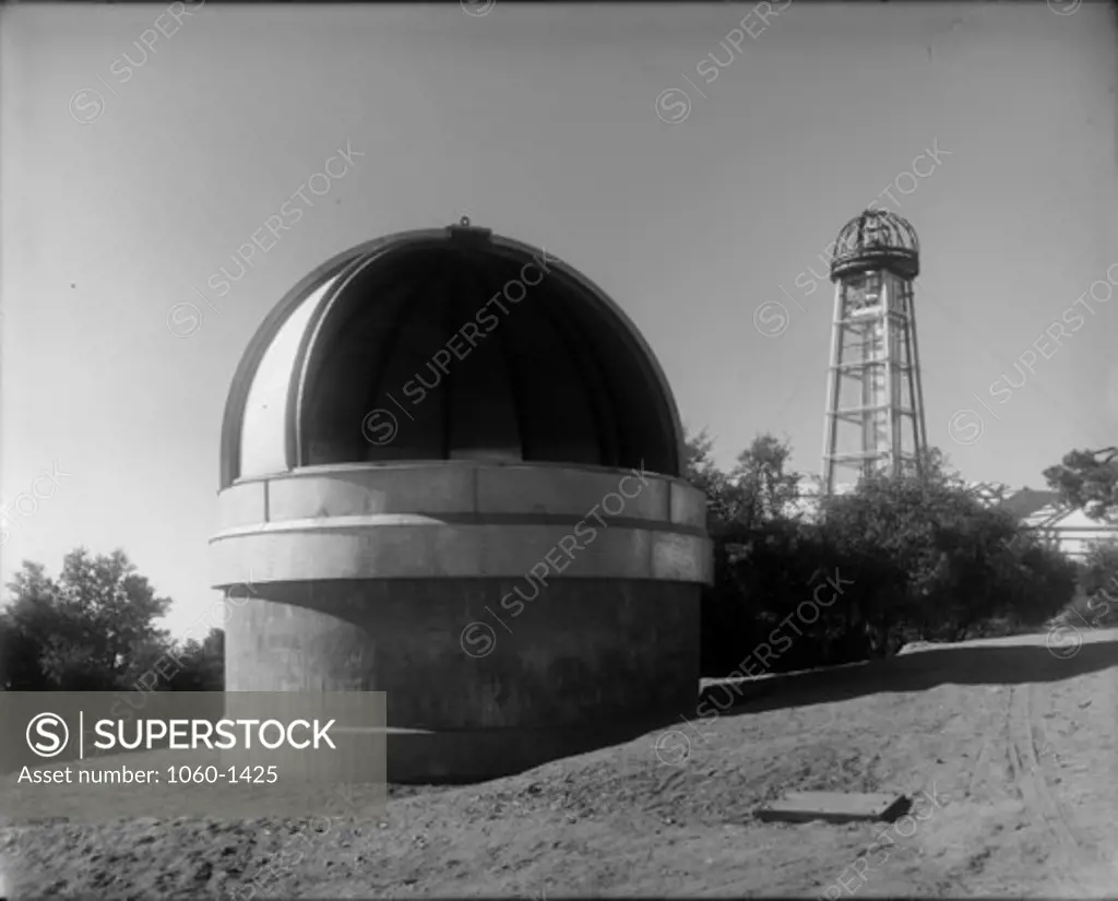 6-INCH TELESCOPE DOME WITH DOME PARTIALLY OPEN; 60-FOOT TOWER TELESCOPE WITH DOME UNDER CONSTRUCTION IN BACKGROUND.