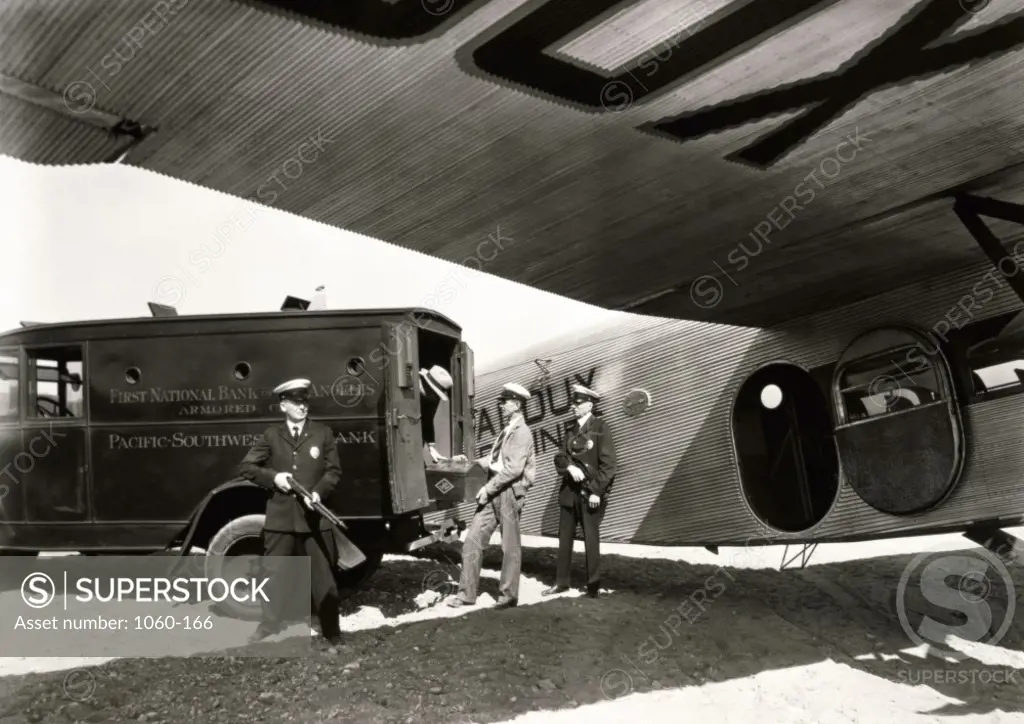 Security guards guarding an armored truck near an aircraft, 1928