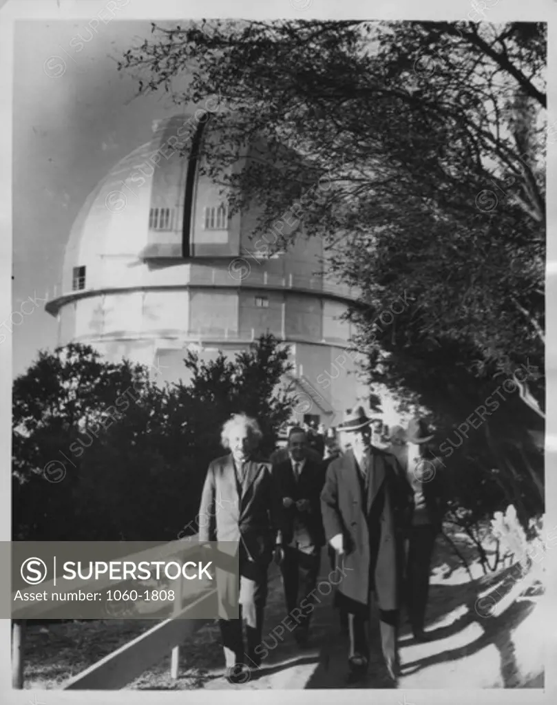 (L to R): Albert Einstein, Walther Mayer, & William W. Campbell walking towards the camera on the footbridge leading away from the 100"" telescope dome (in the background)