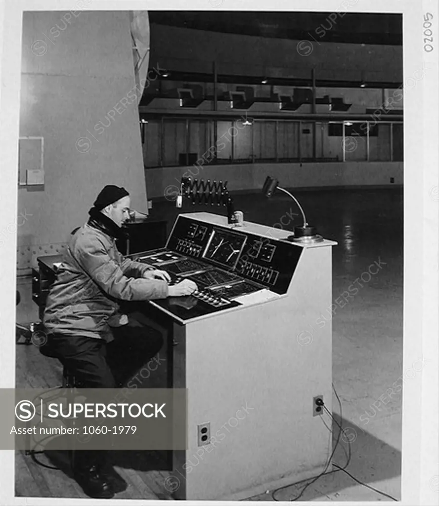 BILL BAUM SITTING AT 200-INCH TELESCOPE CONTROL DESK.