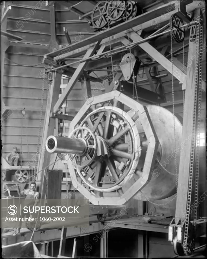 POLAR AXIS & WORM WHEEL OF 60-INCH TELESCOPE HANGING FROM GANTRY ABOVE FLOOR OF PASADENA ERECTING HOUSE.