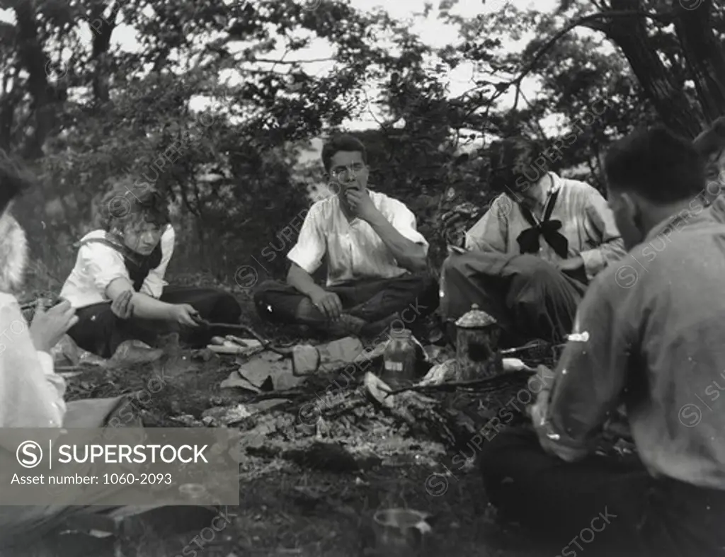 Edwin Powell Hubble (front right--his back) and unidentified companions (three women, girl, and adolescent boy) sitting around camp fire