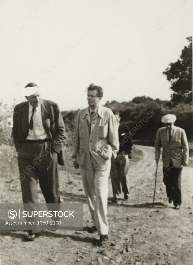 Edwin Powell Hubble, Aldous Huxley, Christopher Isherwood, and John Emerson walking on dirt road