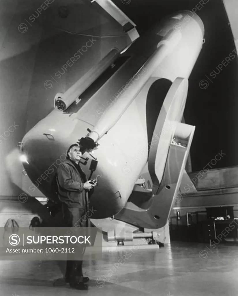 Edwin Powell Hubble looking through Schmidt telescope and smoking pipe
