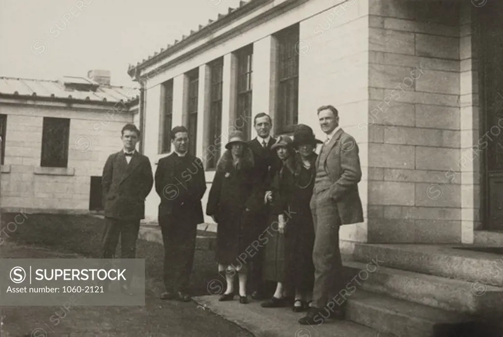 Hubbles with group of people, standing outside building (unidentified man, Le Maitre, Helen Max Burke, Edwin Powell Hubble, Grace (Burke) Hubble, Miss Cameron, and Duncan)