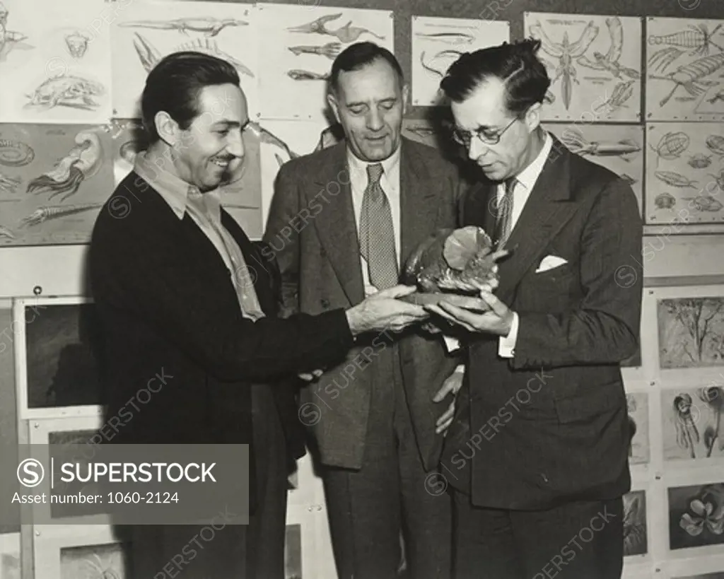 Walter Elias Disney, Edwin Powell Hubble, and Sir Julian Huxley looking at dinosaur model