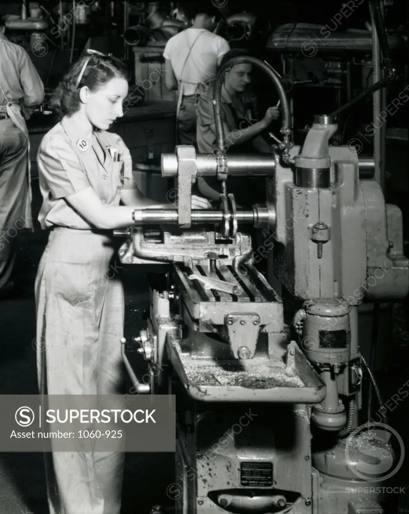 Side profile of a female worker working on a machine in an assembly plant, Vultee Aircraft, 1941