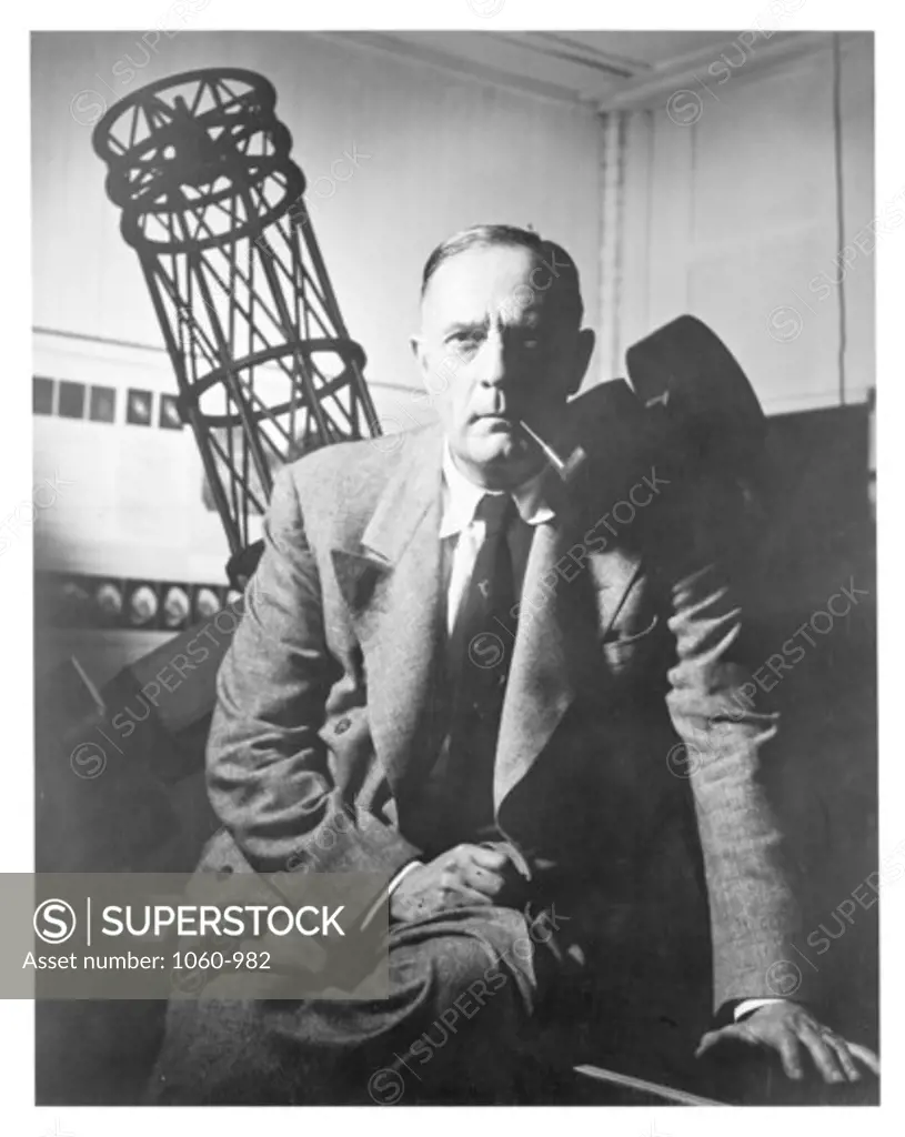 PORTRAIT OF EDWIN HUBBLE AT CARNEGIE INSTITUTION, P STREET OFFICE? IN FRONT OF MODEL OF 100-INCH TELESCOPE.