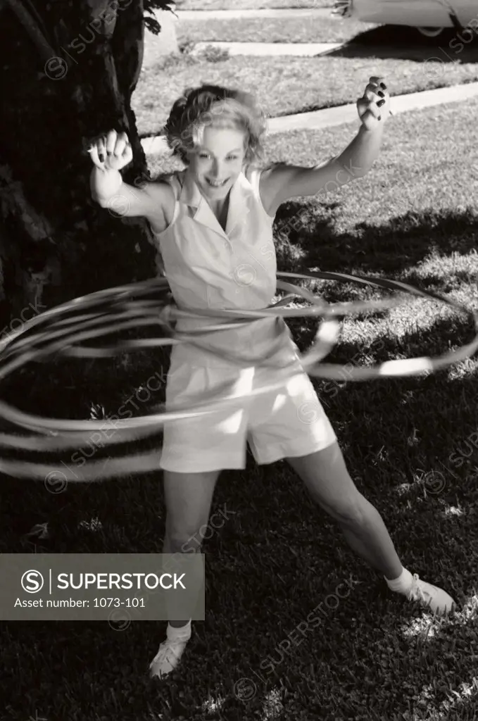 Young woman spinning hula hoops