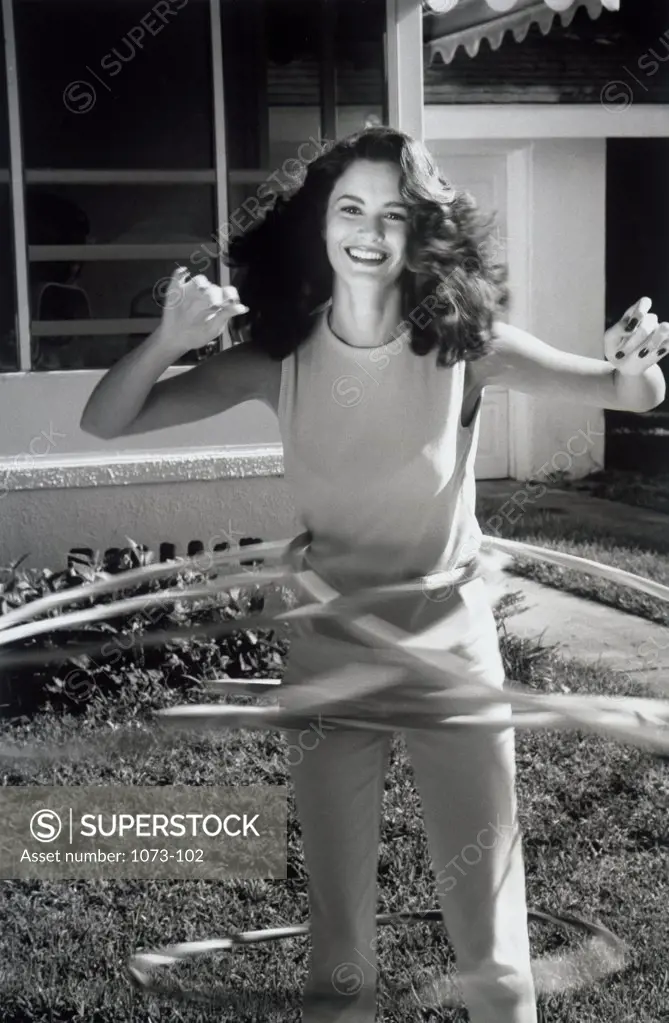 Portrait of young woman playing with hula hoops