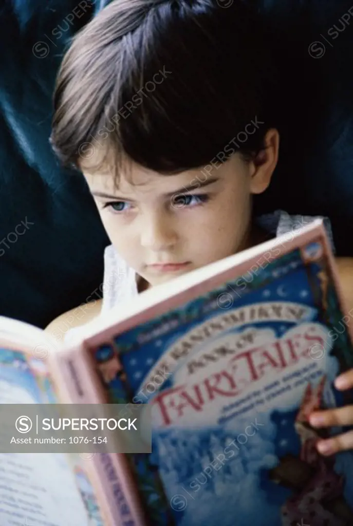 Close-up of a boy reading a fairy tale book