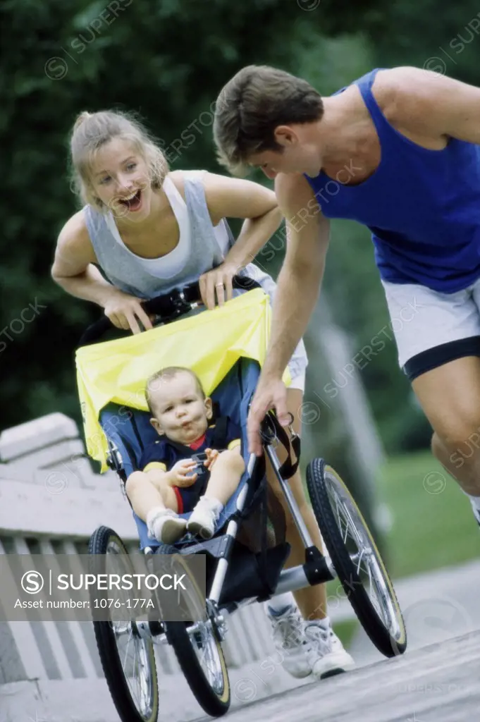 Parents pushing their son in a stroller