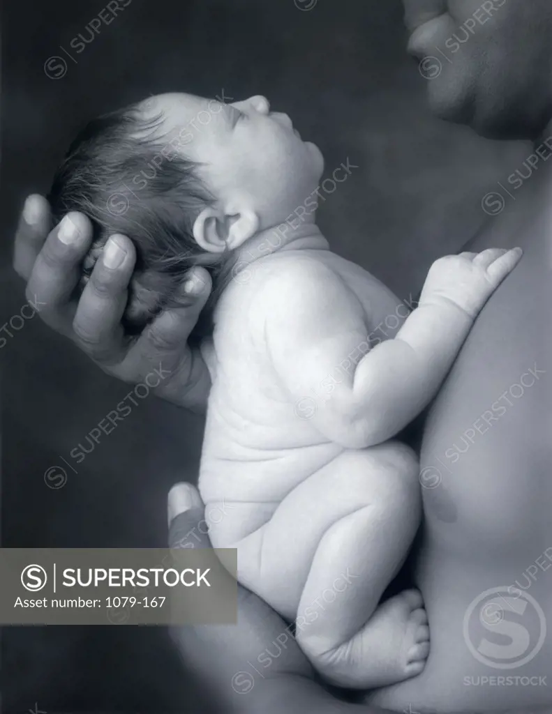 Close-up of a father holding his newborn child