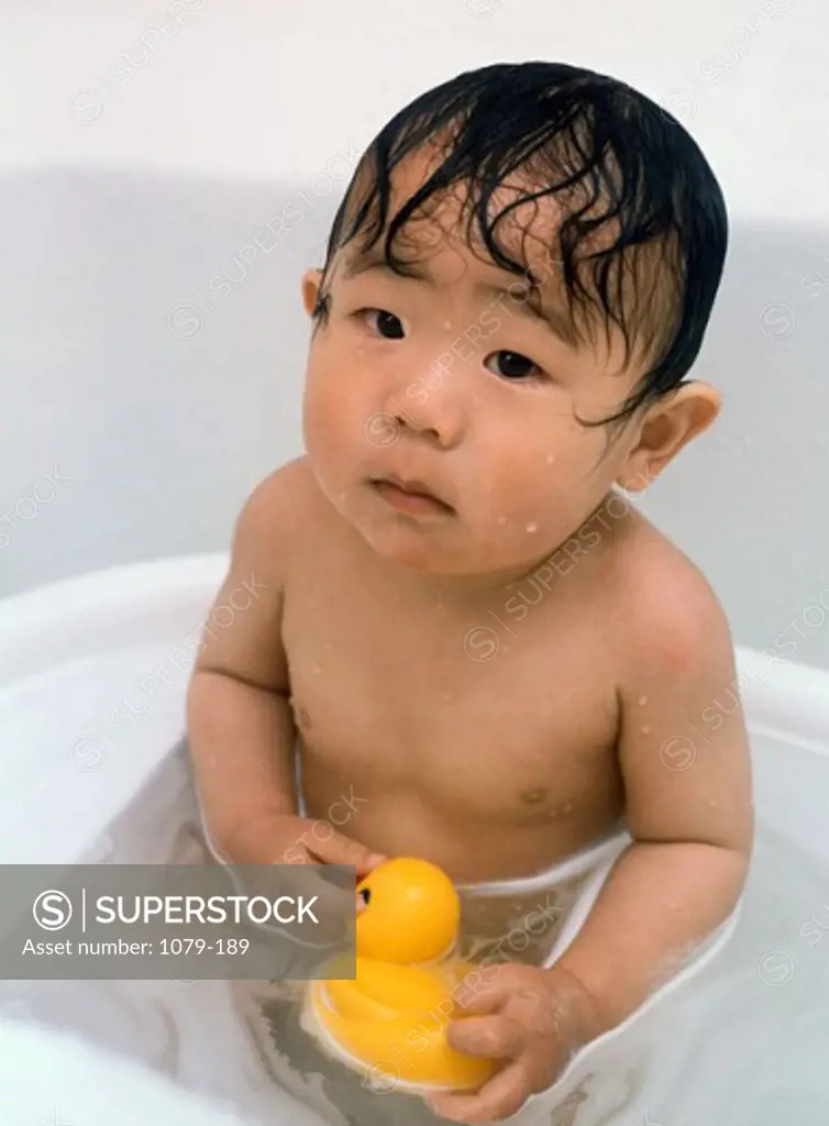 Close-up of a baby boy sitting in a bathtub