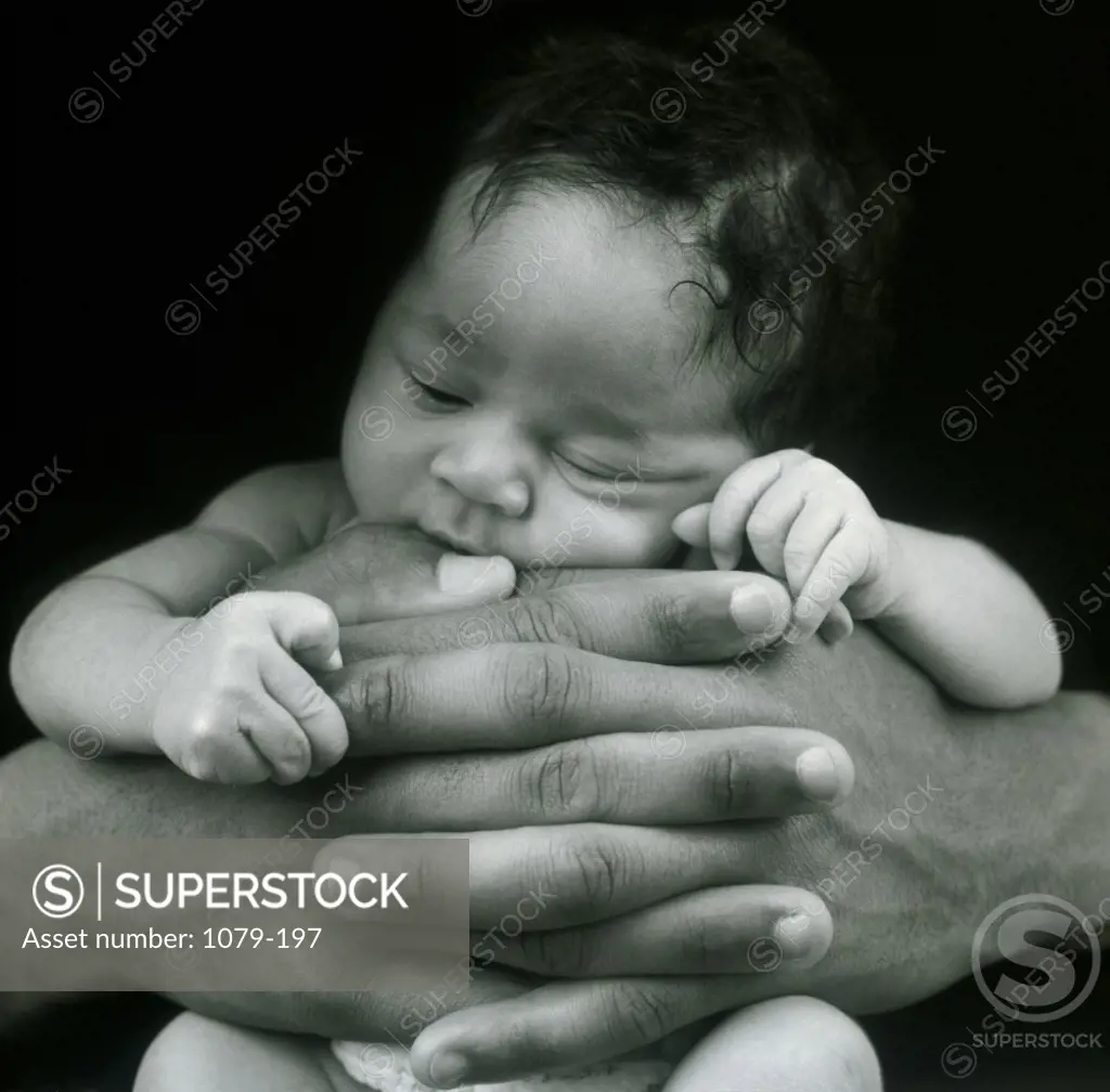 Close-up of human hands holding a baby