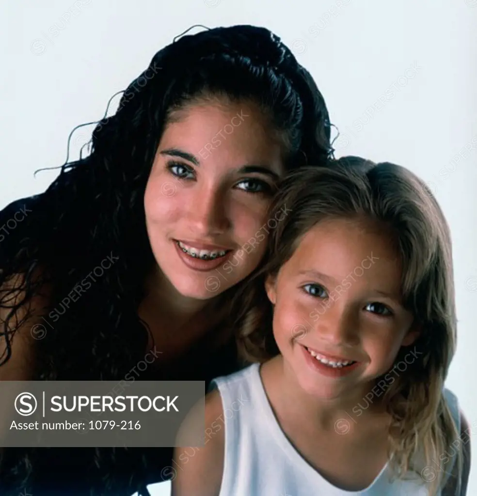 Portrait of a teenage girl and a young girl smiling