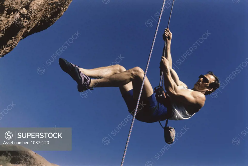 Side profile of a young man climbing a mountain