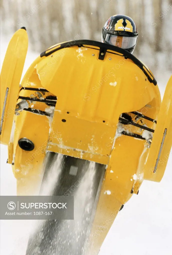 Close-up of a man riding a snowmobile