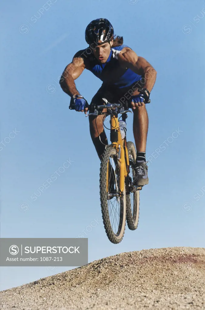 Low angle view of a young man mountain biking