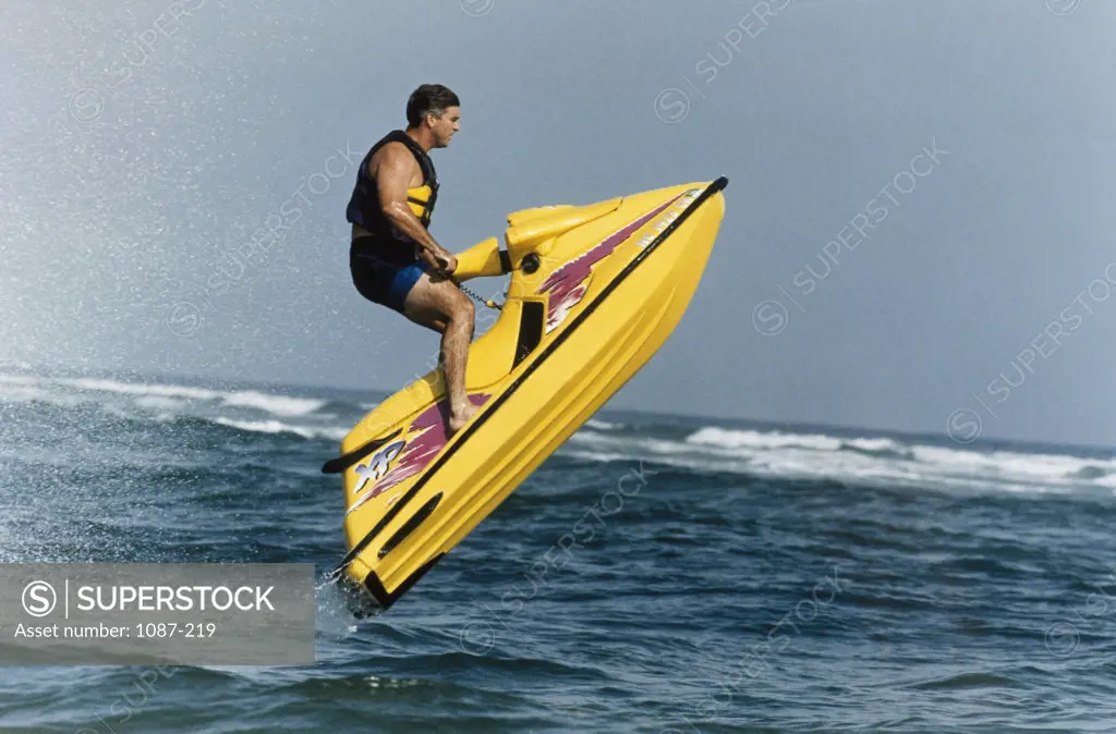 Side profile of a young man riding a jet ski