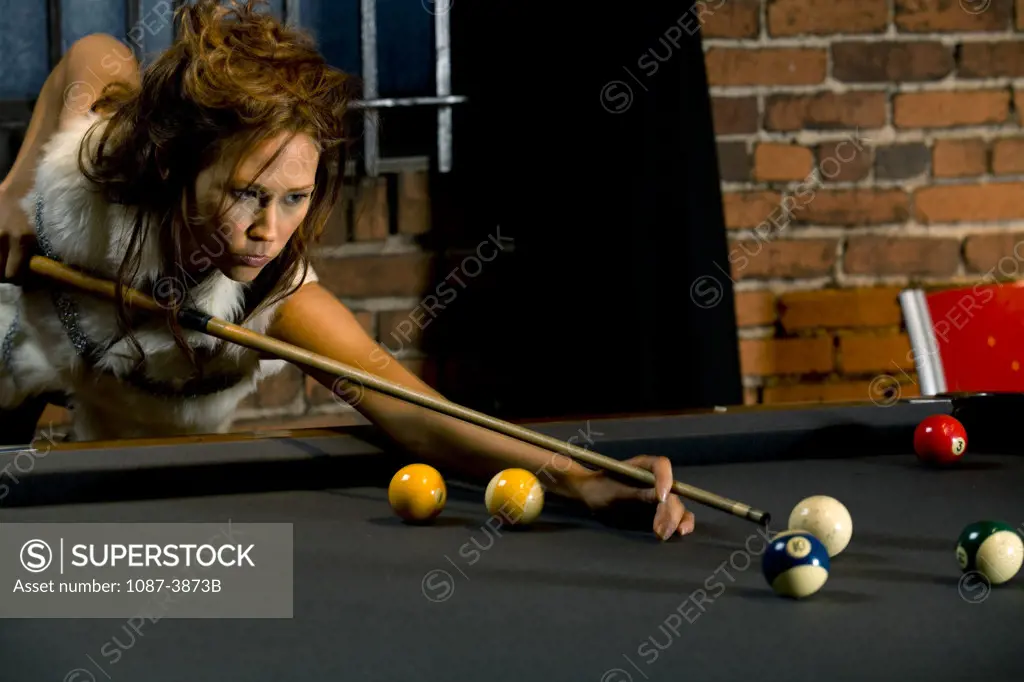 Young woman playing pool game