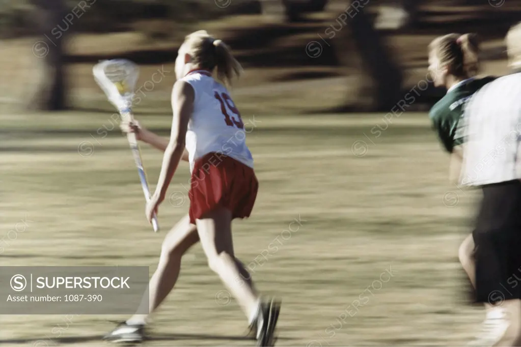 Teenage girls playing lacrosse