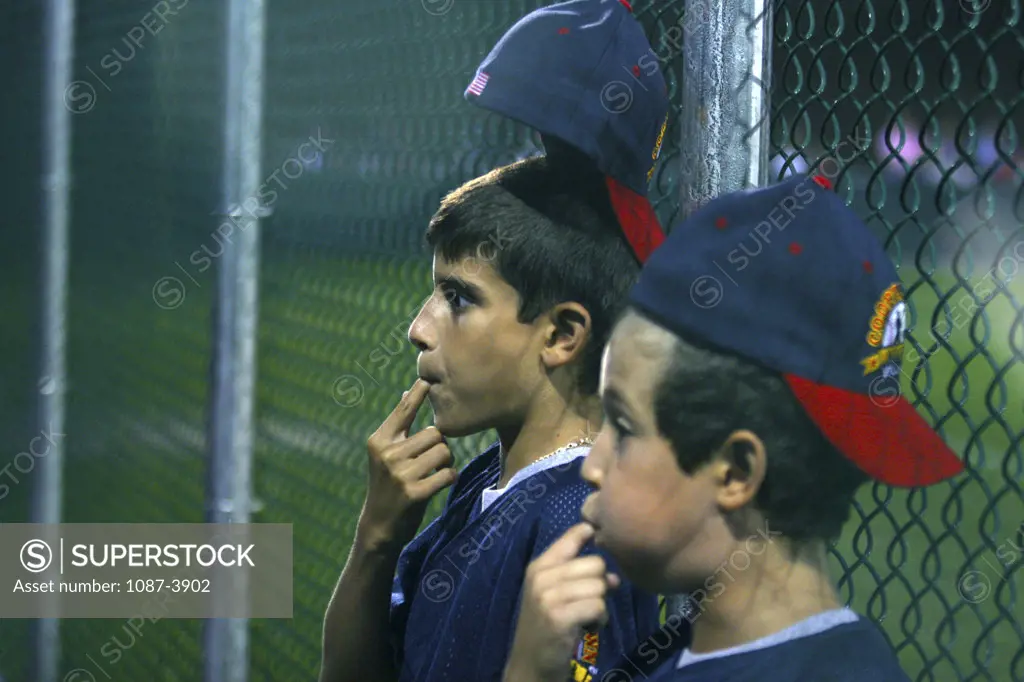 Two boys whistling at a youth baseball game