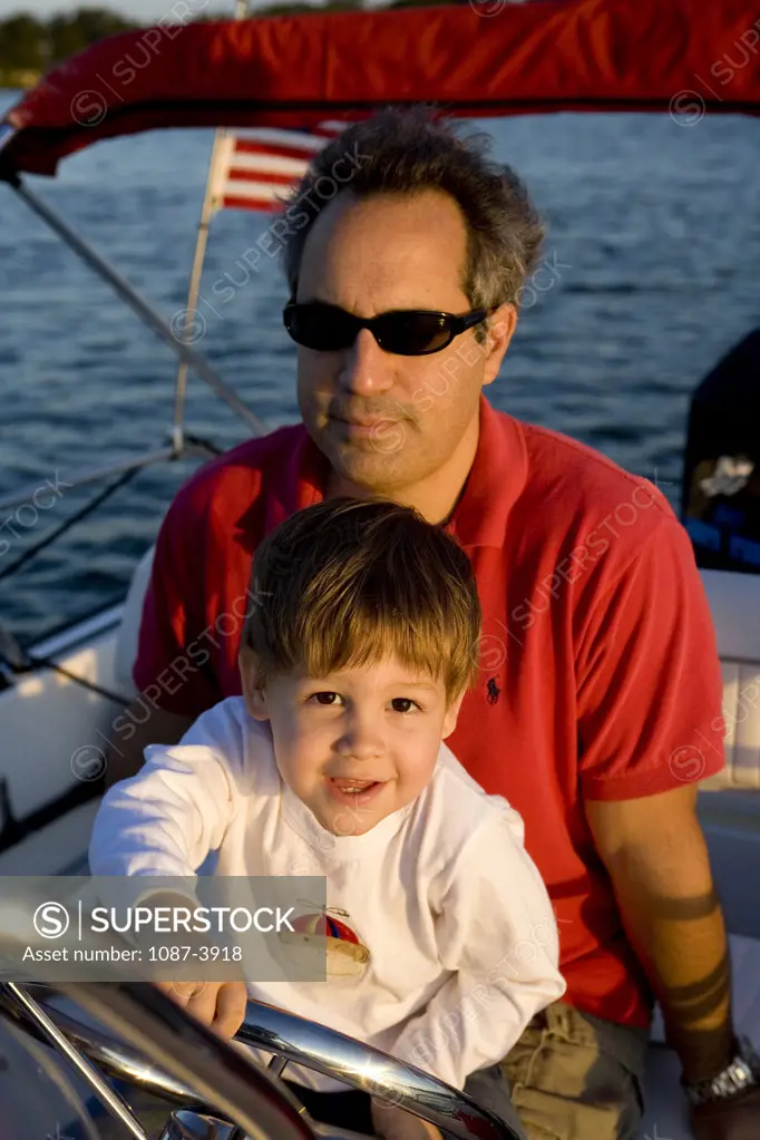 Mid adult man sitting on a boat with his son