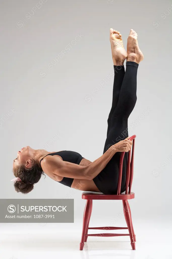 Studio shot of female gymnast on chair