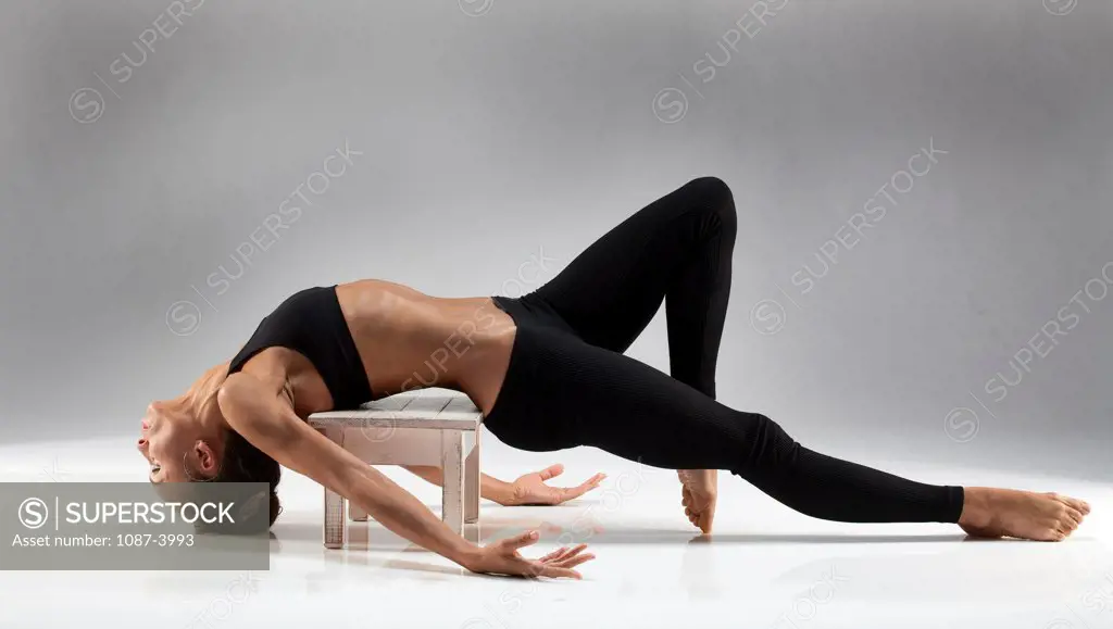 Studio shot of female gymnast on stool