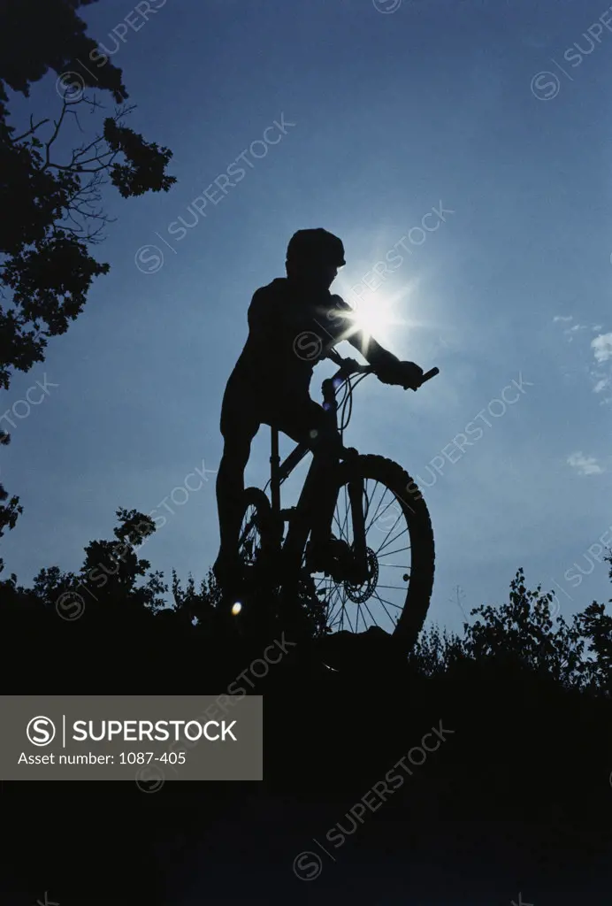 Silhouette of a person mountain biking