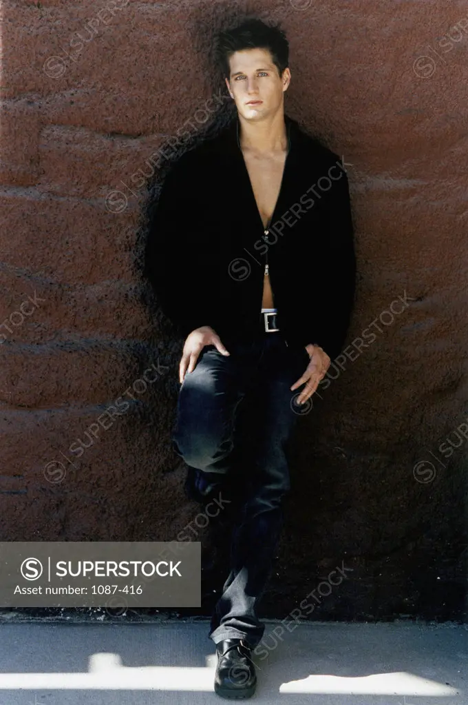 Portrait of a young man leaning against a wall