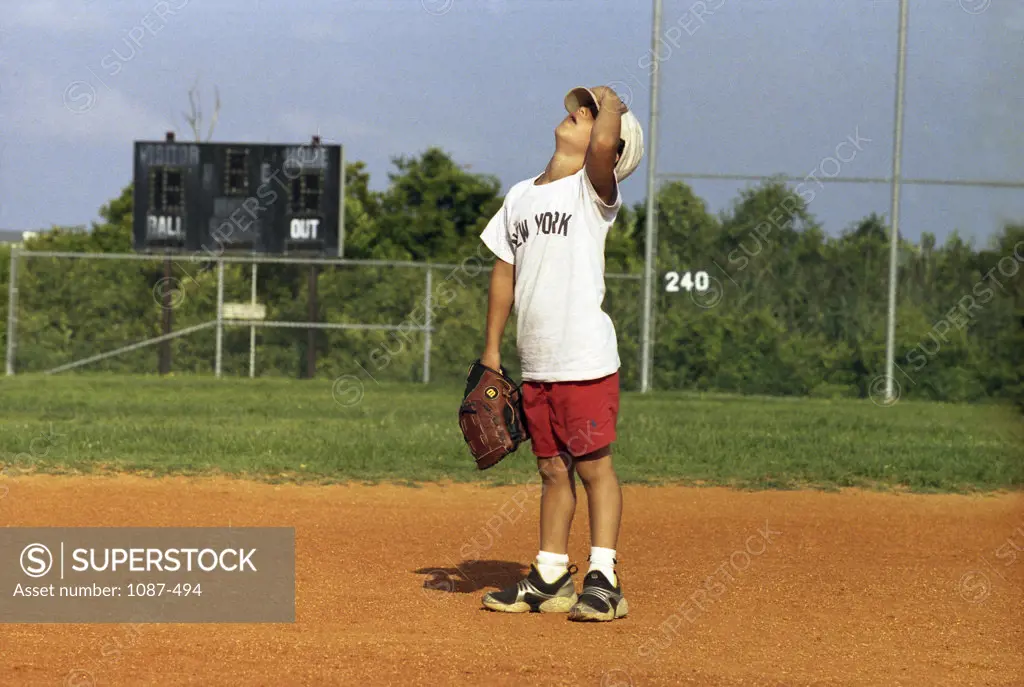 Boy standing in a baseball field