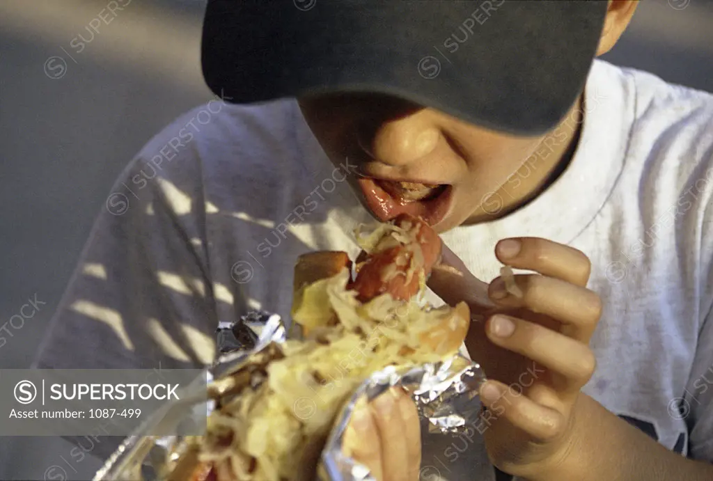 Close-up of a boy eating a hot dog